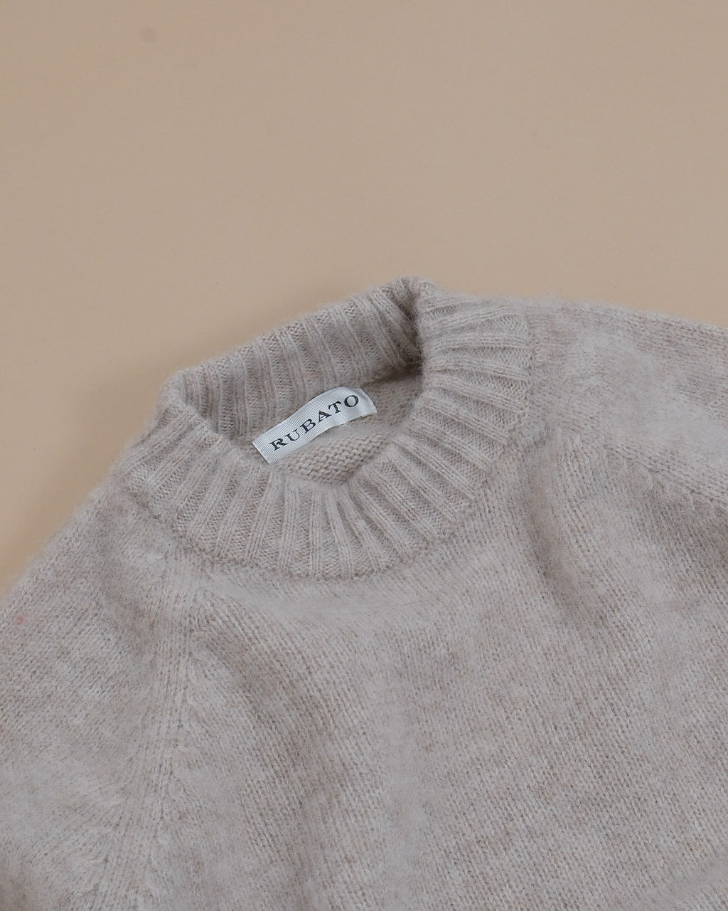 Detail of the ribbed neckline and raglan shoulder construction on the Harbour Brushed Shetland Crewneck by Rubato. 