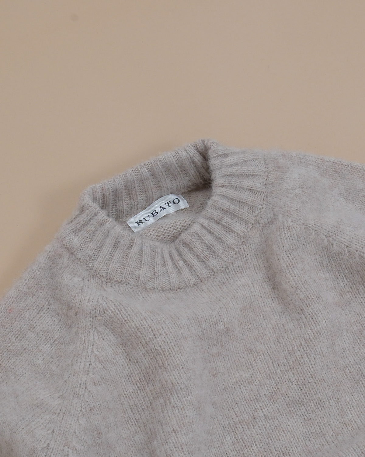 Detail of the ribbed neckline and raglan shoulder construction on the Harbour Brushed Shetland Crewneck by Rubato. 