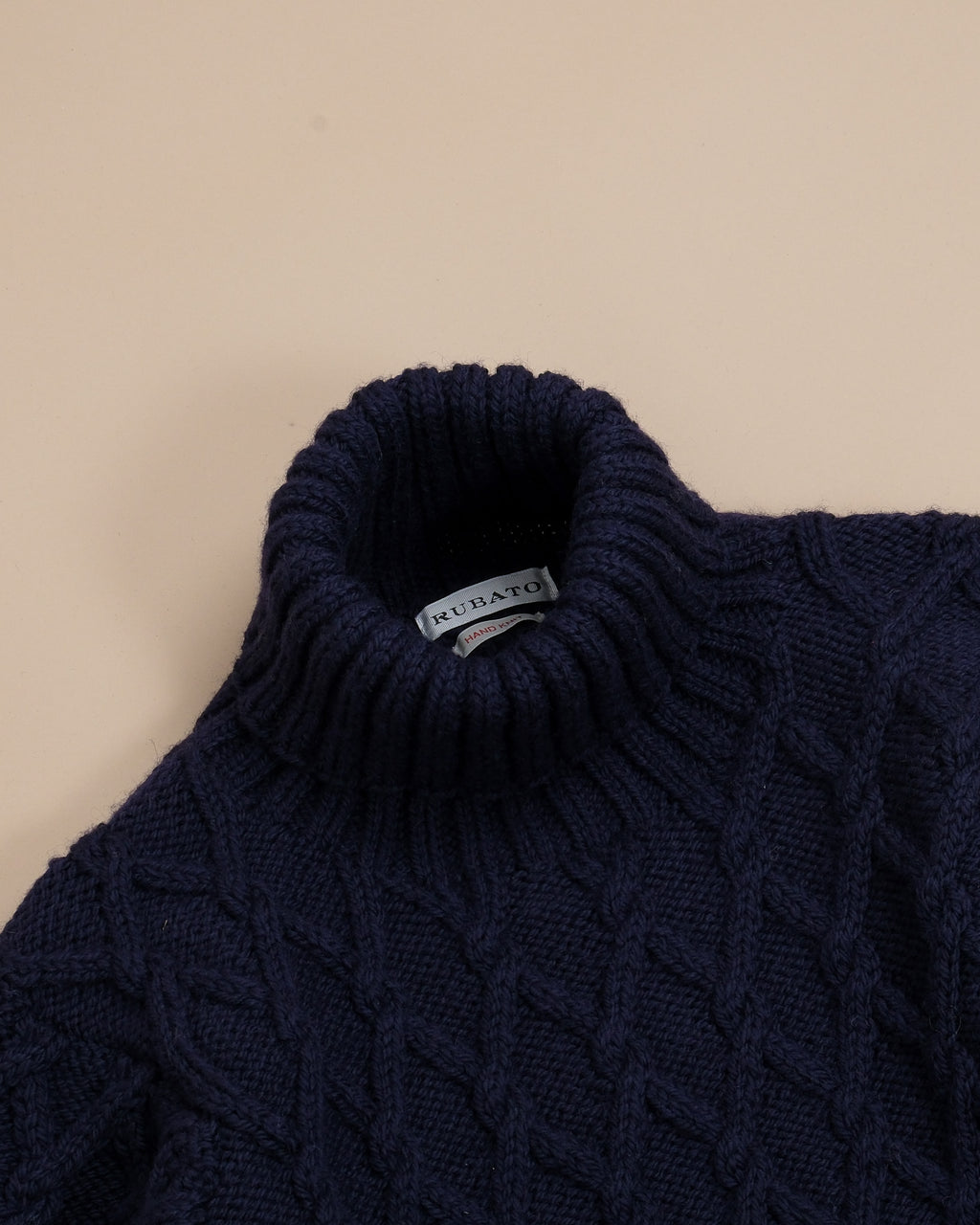 Detail of the cable-knit structure and generously ribbed rollneck on the Navy Hand-Knitted Mariner by Rubato. 