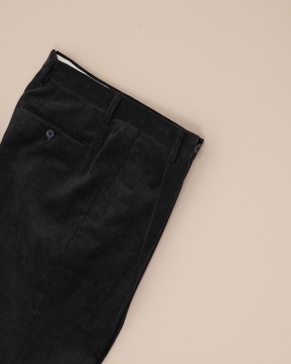 Detail of the single reverse pleated front on the Black Cord Pleated Trousers by Rubato