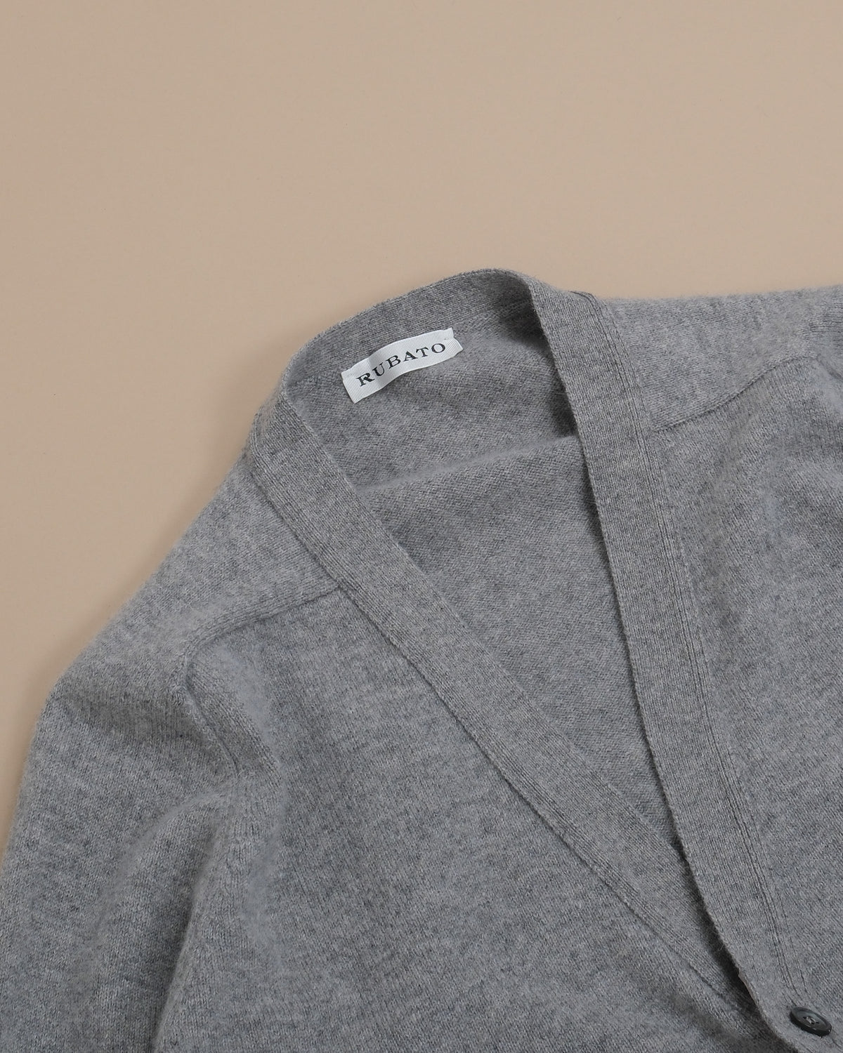 Detail of the saddle shoulder and ribbed deep V-neck on the Stone Lambswool Standard Cardigan by Rubato